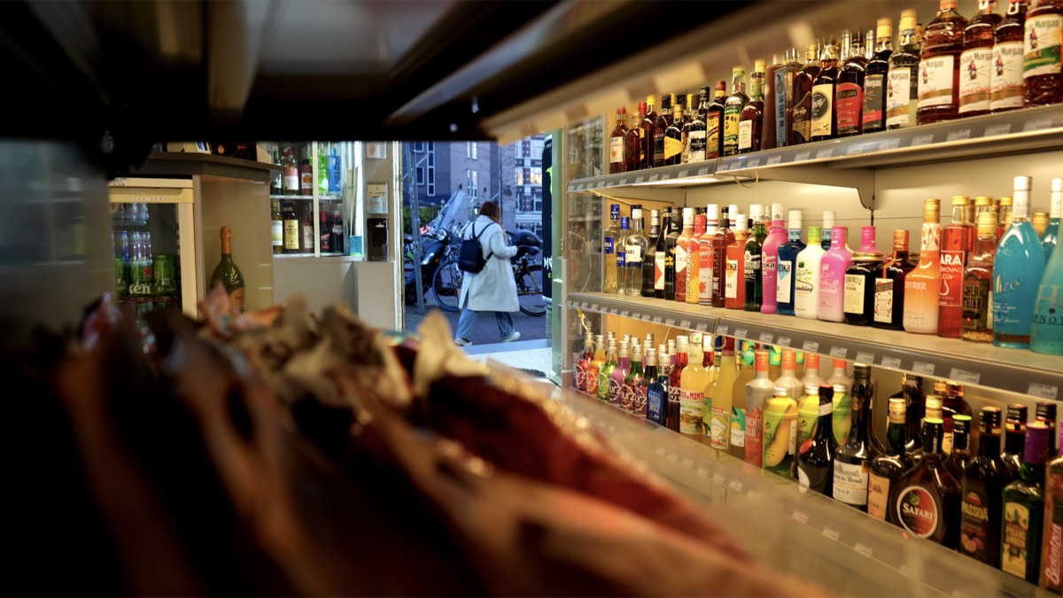 Inside Slijterij United Liquors, Amsterdam — bottle shelves with the street visible through the doorway