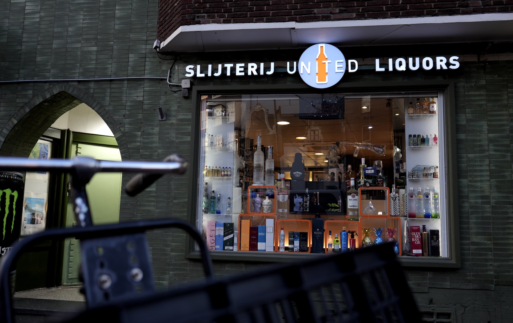 Slijterij United Liquors storefront at night near Amsterdam Centraal